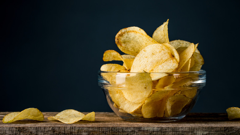 potato chips in a glass bowl on a wooden table