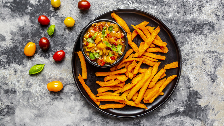 Sweet potato fries on a plate with tomatoes