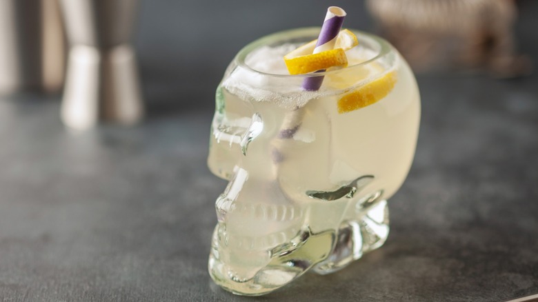 A Corpse Reviver drink in a skull glass with lemon