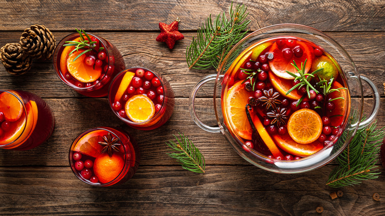 Fruity Christmas punch bowl and several glasses on a wooden table