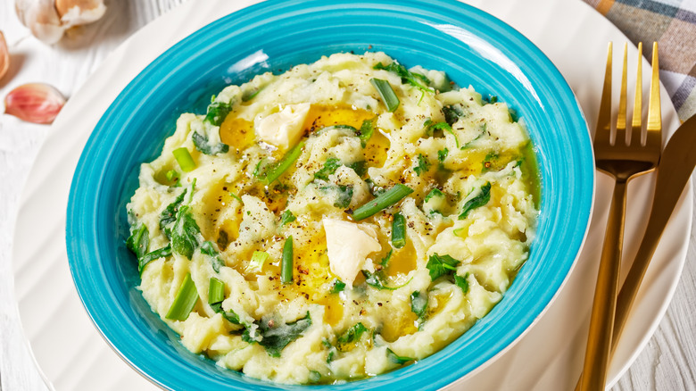 Colcannon in a blue bowl topped with butter