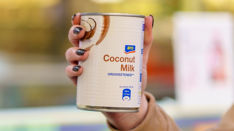 Hand holding canned coconut milk