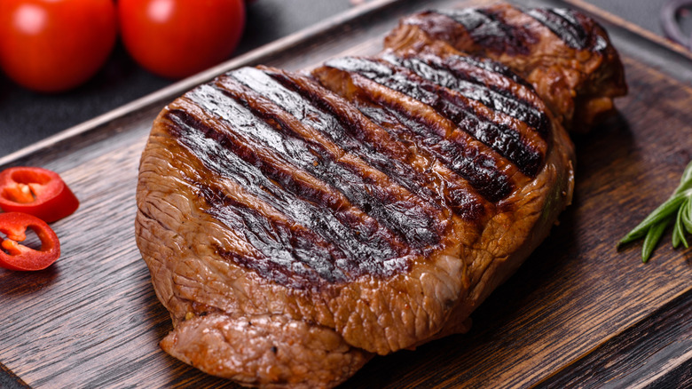 Grilled chuck eye steak on wooden board