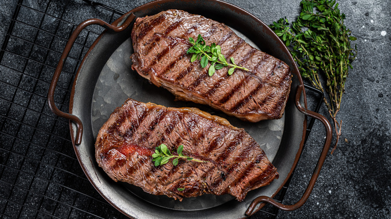 Grilled flat iron steaks in metal dish