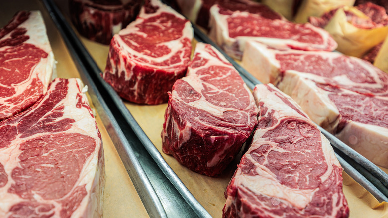 Cuts of thick raw steak in display case