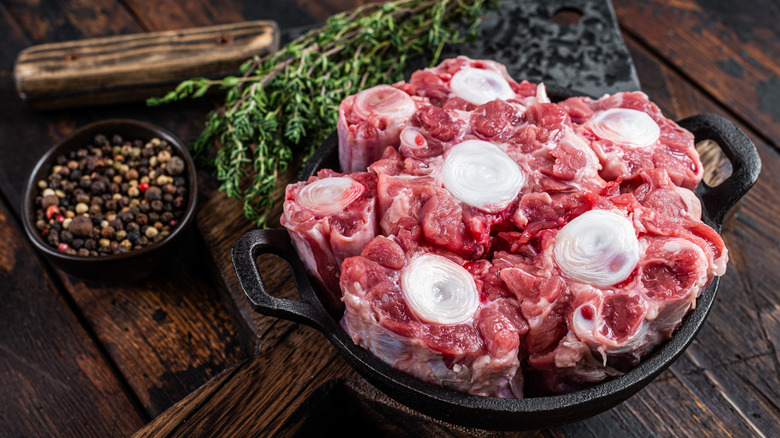 Raw oxtail meat in cast iron dish