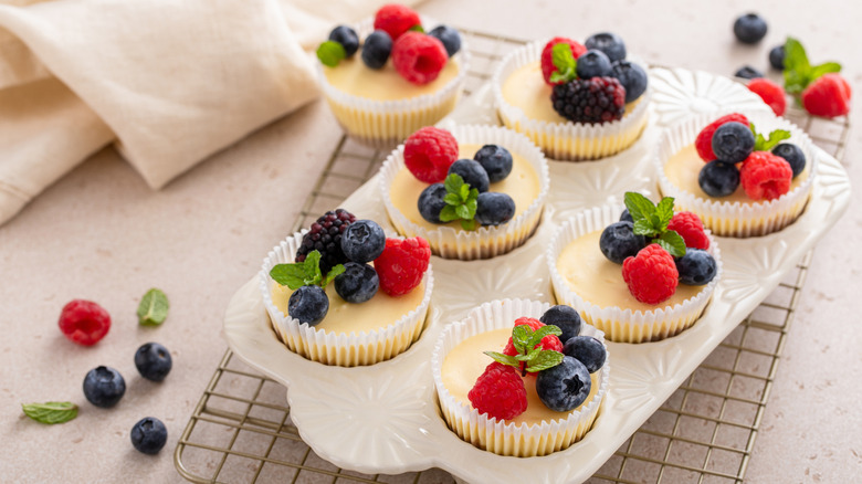 A batch of mini cheesecakes baked using a muffin pan.