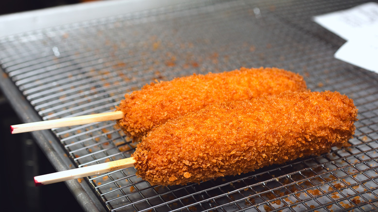 Corn dogs cooling on a rack