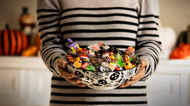 woman holding bowl of halloween candy