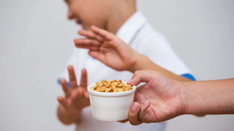 boy refusing bowl of peanuts