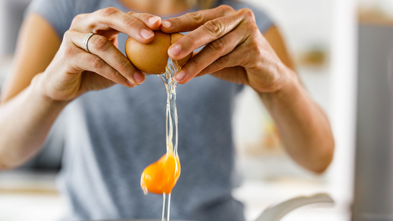 Woman cracking egg in bowl
