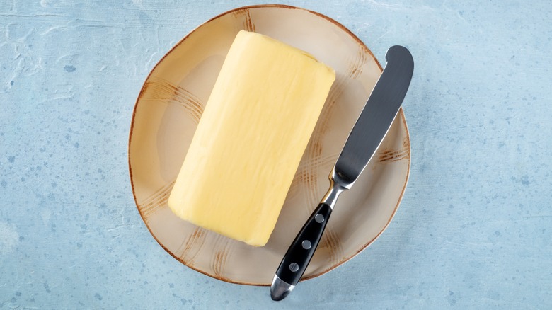 slab of butter on plate with butter knife