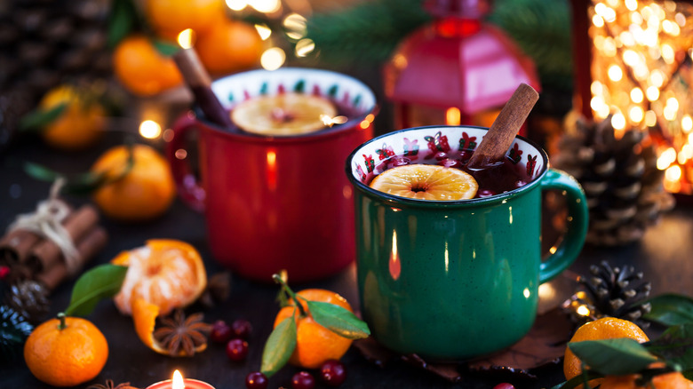 Mulled wine in red and green mugs with a festive holiday background