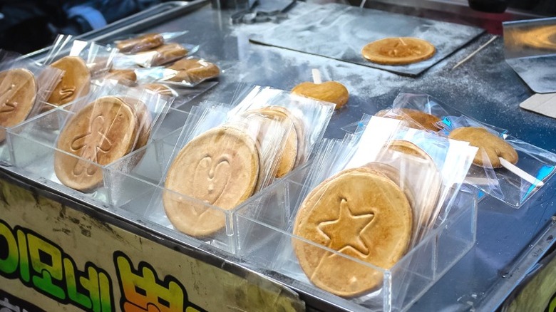 Korean street food stand displaying individually wrapped dalgona candies