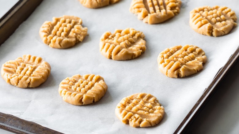 Peanut butter cookies on a baking sheet with parchment paper