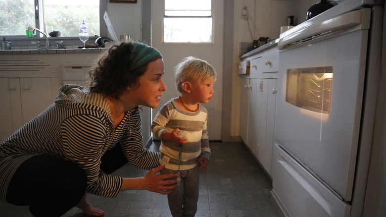 parent and child looking into the oven through the door