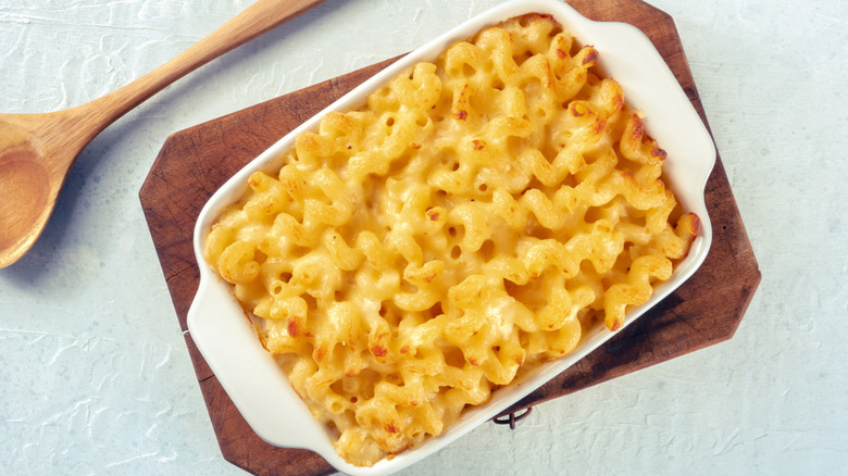 Baked macaroni and cheese in a casserole dish its on a trivet