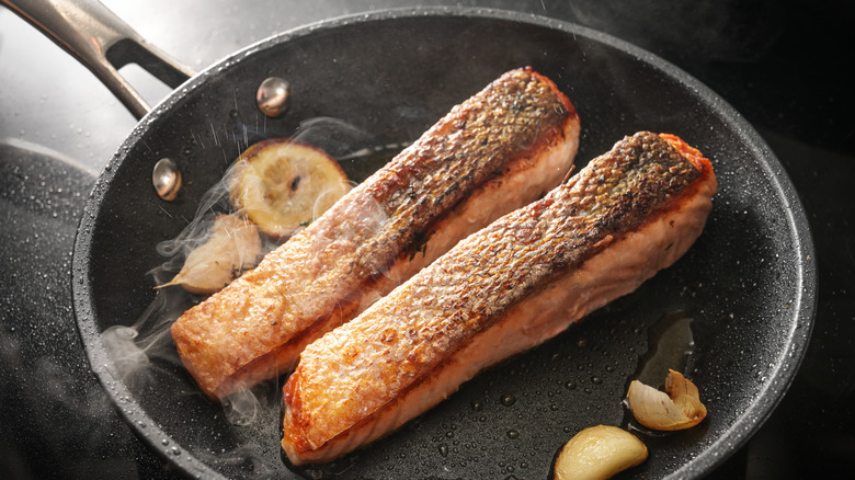 Seared salmon in pan with crispy skin