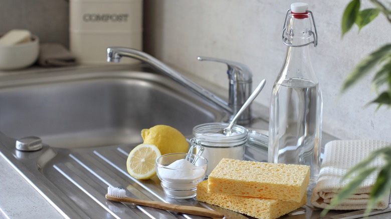 Lemon and cleaning supplies on a kitchen sink