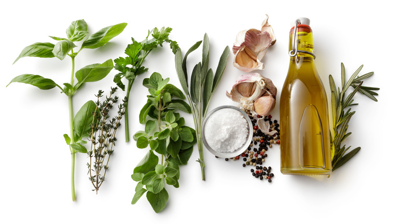 A row of fresh herbs, garlic, salt, and oil