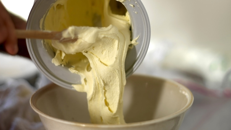 person pouring base into ice cream machine