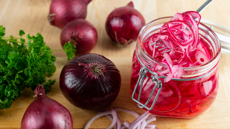 Jar of pickled red onions and pickling ingredients