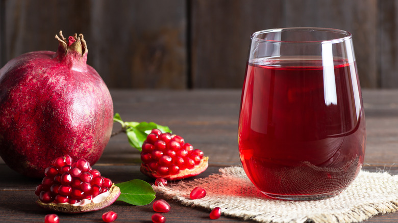 glass of grenadine next to pomegranate