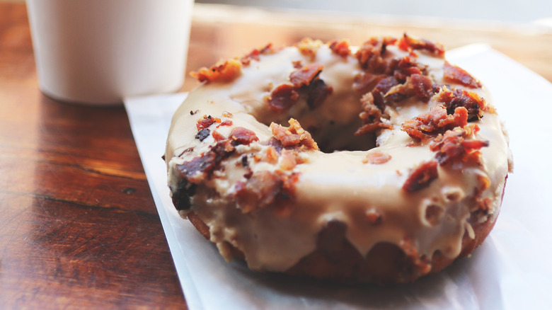 Maple and bacon donut next to coffee