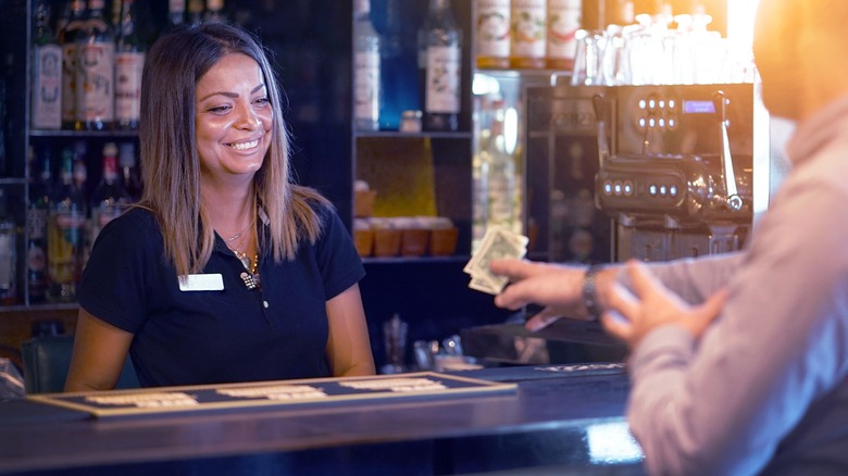 Happy bartender receiving a tip