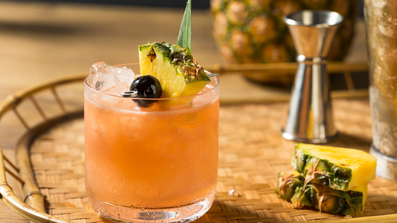 Close-up of a mai tai garnished with pineapple and luxardo cherry