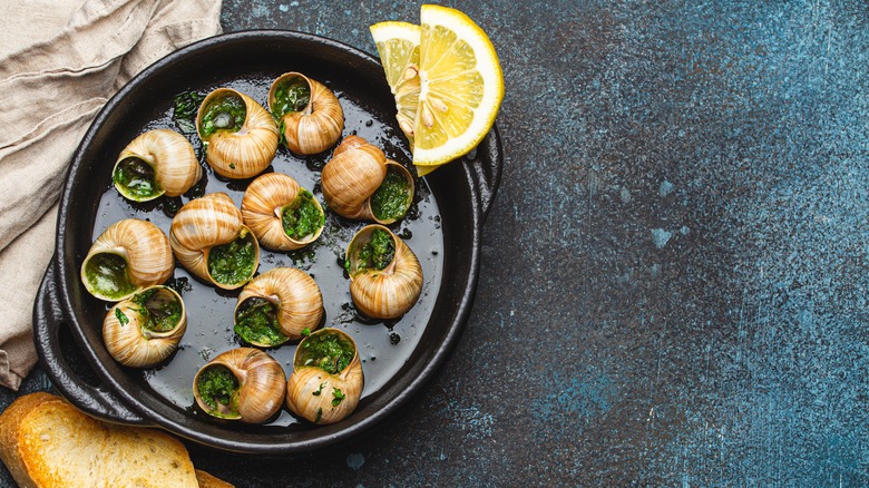 Escargot in cast iron skillet with lemon