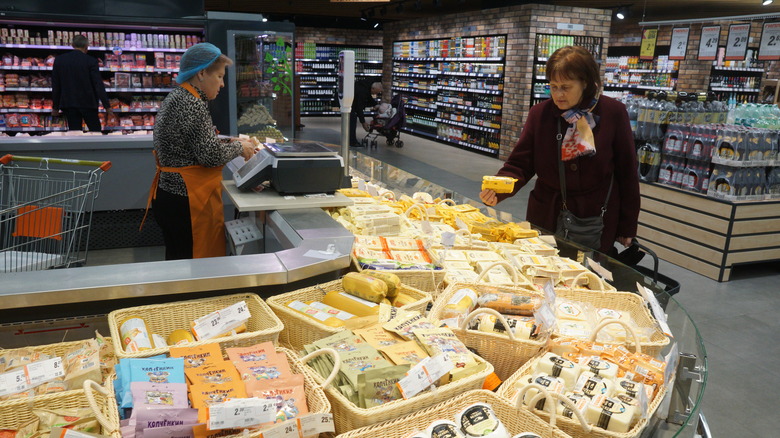 Woman examining cheese counter in store