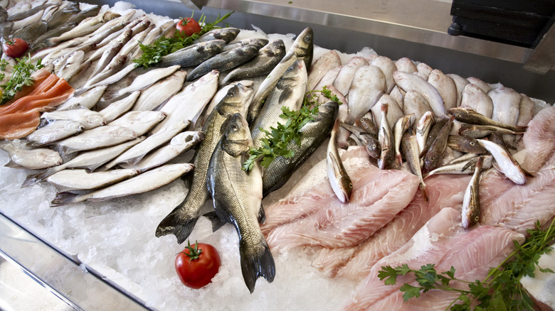 A refrigerated case of whole fish and various fillets at the store