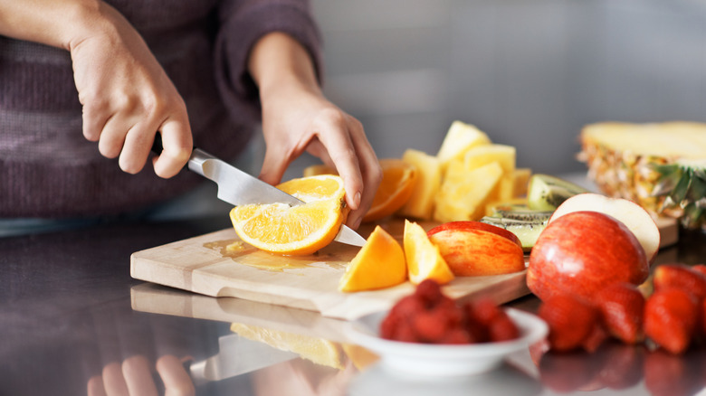 Woman cutting citrus fruit