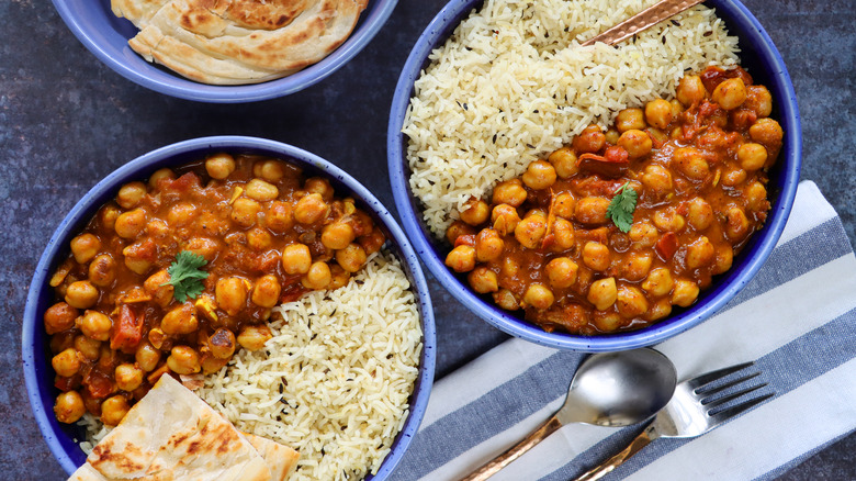 Indian curry in bowls with rice chickpeas chana Punjabi chole