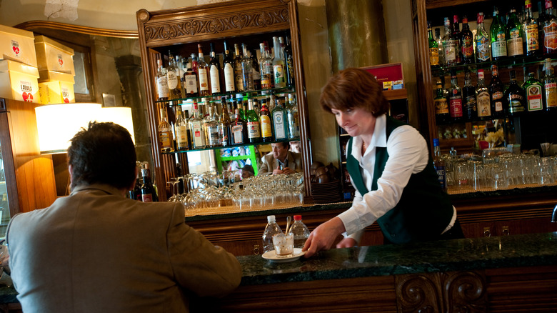 Woman taking coffee cup at bar in Italy