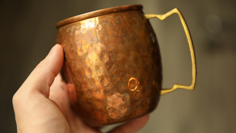 hand holding copper mug
