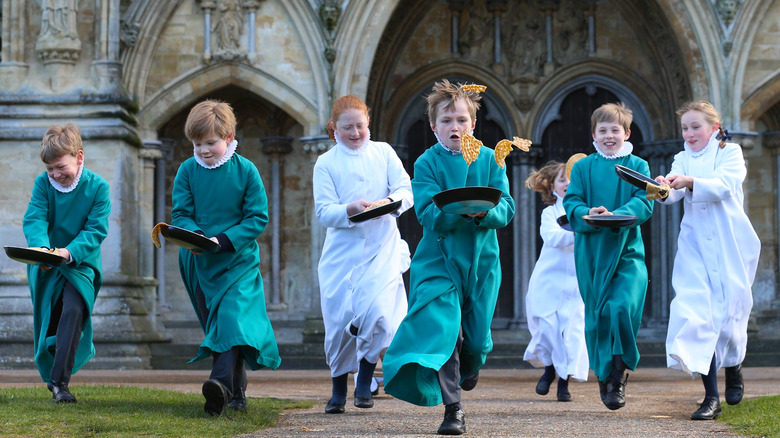 British children in religious dress running in Pancake Day race