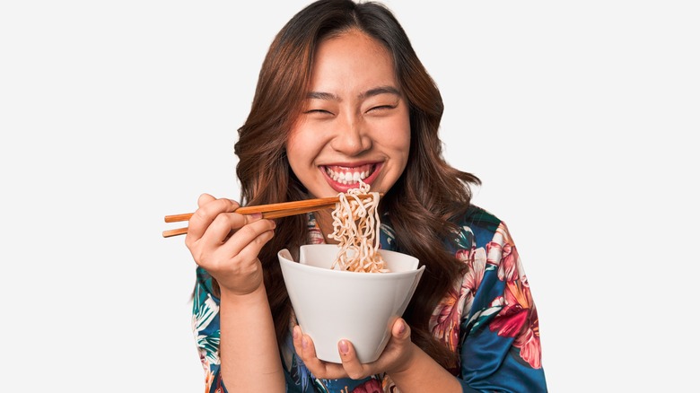 Woman eating noodles with chopsticks