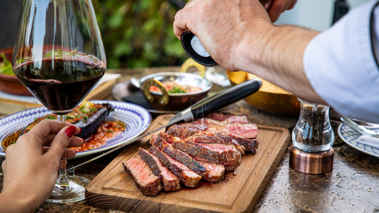 salting steak at restaurant table