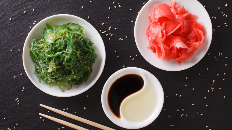 bowls of pickled ginger and seaweed salad