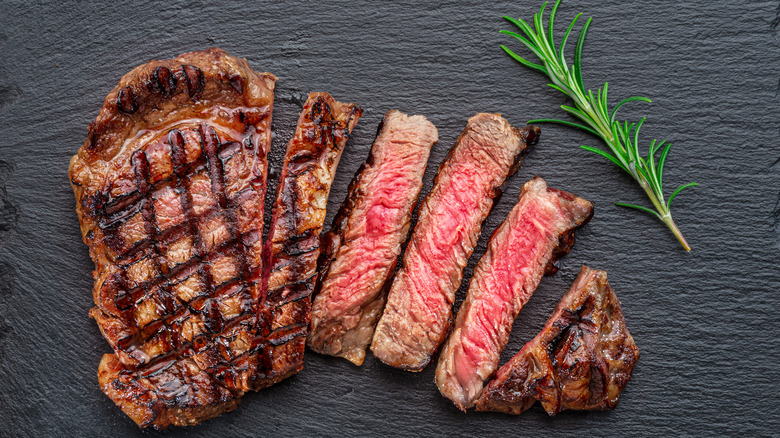 Grilled steak sliced on black slate