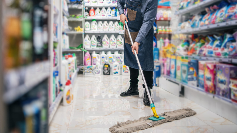 Employee cleaning grocery store aisle