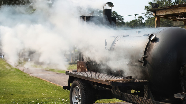 A barbecue smoker in action