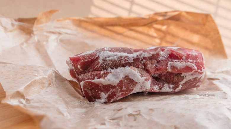 Frozen meat with ice crystals on the outside.