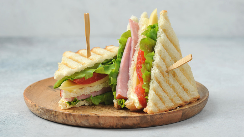 Club sandwich on wooden plate