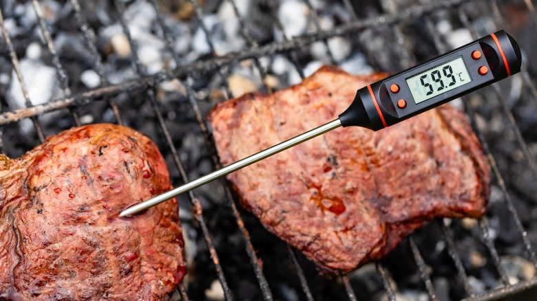 Using a thermometer to check the temperature of a steak