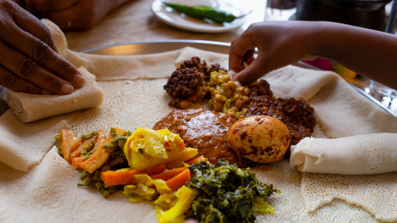 Eating Ethiopian injera meal by hand