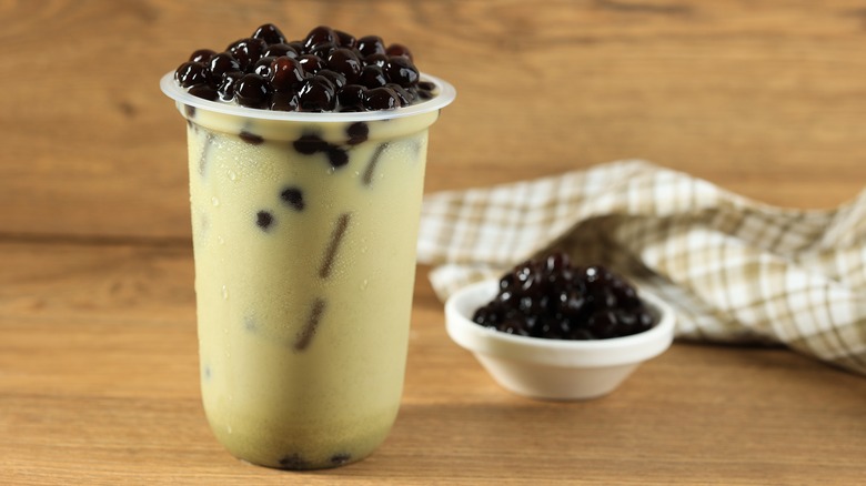 A glass of bubble tea with tapioca pearls on top