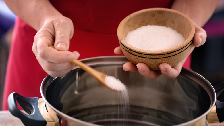 Adding salt to pot of water